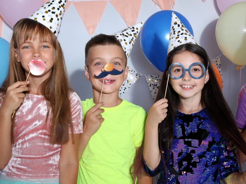 Home Happy-children-with-photo-booth-props-at-birthday-party-indoors